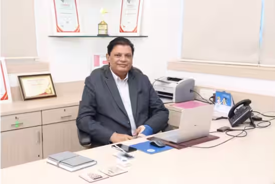 Dr. Balkrishna Parab sitting at his desk